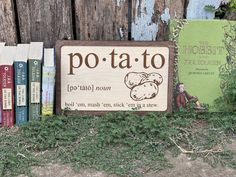 there is a sign that says po - ta - to on it next to some books