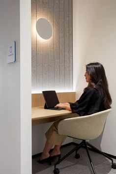 a woman sitting at a desk using a laptop computer