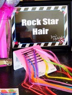 there is a sign that says rock star hair next to some scissors and streamers