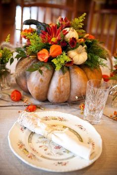 a table set with pumpkins, flowers and other decorations for thanksgiving or fall dinner