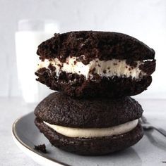 two chocolate cookies with ice cream and oreo cookies on the top one is half eaten