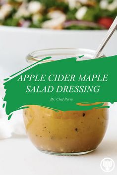 an apple cider maple salad dressing in a glass jar with a spoon on the side