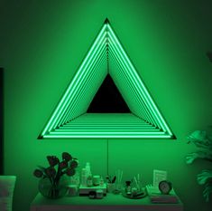 a green room with a triangle shaped mirror and various items on the table in front of it