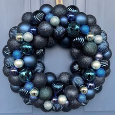 a blue and silver christmas ornament wreath hanging on a door