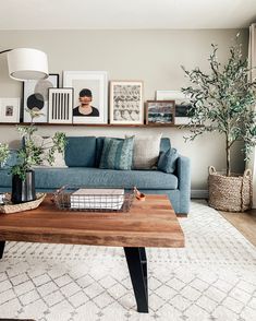 a living room with blue couches and pictures on the wall above it's coffee table