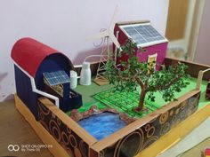 a toy house with solar panels on the roof and trees in the yard, along with other toys