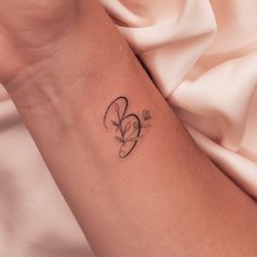 a woman's arm with a small heart tattoo on the left side of her arm