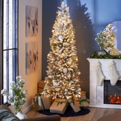 a white christmas tree with presents under it