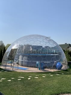 an inflatable swimming pool sits on top of a lawn and surrounded by green grass