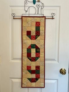 a door hanger with a quilt hanging from it's side on a white door