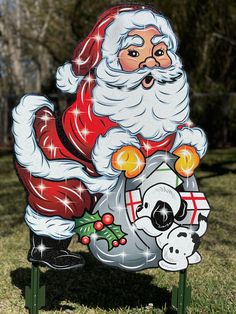 a santa clause sitting on top of a sign in the grass