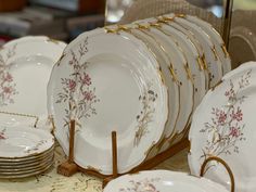 a table topped with lots of white and gold plates