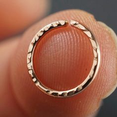 a close up of a person's finger with an open ring on top of it