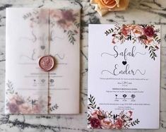 the wedding stationery is laid out on top of the marble table with a rose