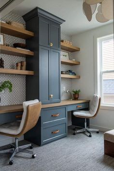 a home office with built in shelving and desk area, along with two chairs