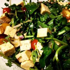 a salad with tofu, spinach and cherry tomatoes