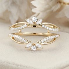 a yellow gold ring with two white diamonds on top and one diamond in the middle