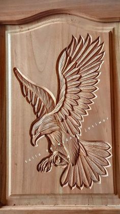 an eagle carved into the side of a wooden plaque