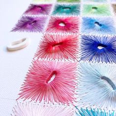 the scissors are laying on the table with different colored thread spools