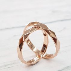 two wedding rings sitting on top of each other