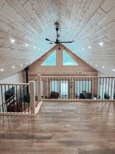 an empty room with wood flooring and ceiling fan