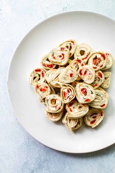 a white plate topped with rolled up food