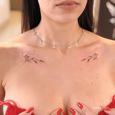 a woman with tattoos on her chest wearing a red bra