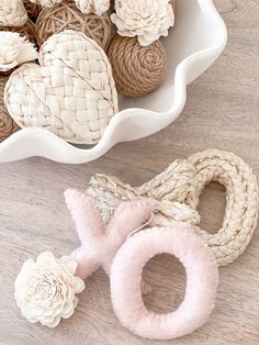 a bowl filled with knitted flowers next to a pair of crochet scissors