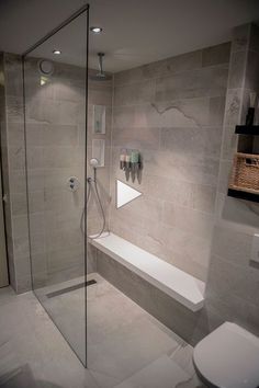 a bathroom with a walk in shower next to a toilet