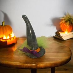 a table with two pumpkins and a witches hat on it