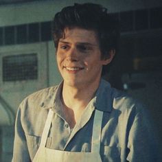 a man in an apron is smiling for the camera