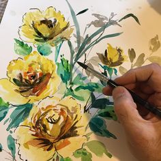 a person is painting flowers with watercolors