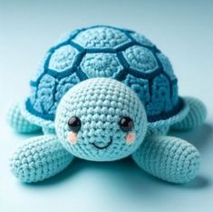 a crocheted turtle is sitting on the floor with its eyes closed and it's head turned to the side