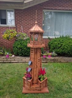 a wooden clock tower sitting in the grass