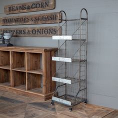 a metal shelf sitting next to a wooden cabinet on top of a hard wood floor