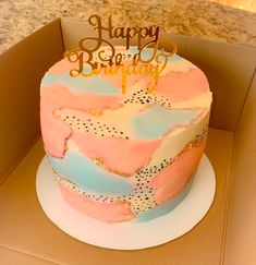 a pink and blue birthday cake in a box