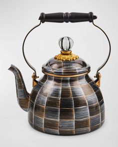 a black and gold tea kettle with a handle