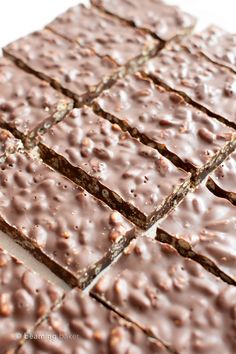 chocolate brownies are arranged on a white surface