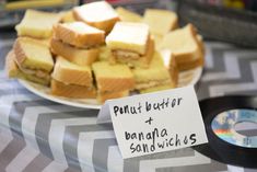 a table topped with lots of different types of sandwiches and cake on top of it