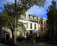 a row of multi - family houses on a sunny day in the city with trees and bushes