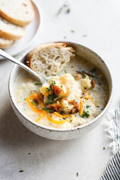 a bowl of soup with bread on the side