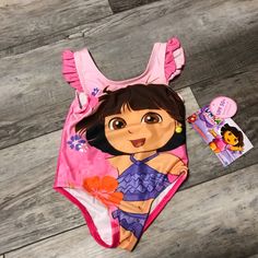 New With Tag Dora Bathing Suit Cute Cartoon Print Swimwear For The Beach, Cute Cartoon Print Swimwear For Beach, Cute Swimwear With Character Print For The Beach, Cute Character Print Swimwear For Beach, Cute Beach Swimwear With Character Print, Cute Character Print Beach Swimwear, Cute Swimwear With Character Print For Playwear, Cute Character Print Swimwear For Playtime, Cute Character Print Swimwear For Playwear