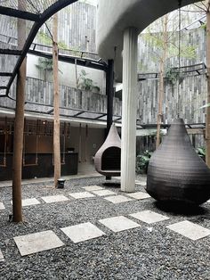 a large black vase sitting on top of a checkered floor next to tall trees