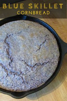 blue skillet cornbread in a cast iron pan on a wooden table with text overlay that reads, blue skillet cornbread