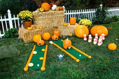 pumpkins and hay bales are arranged on the lawn