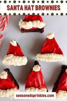 santa hat brownies with white frosting and candy canes on the side for christmas