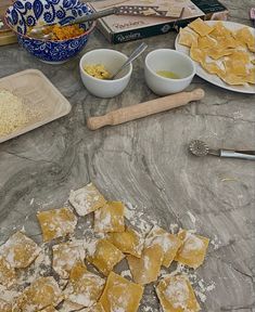 some food is laying out on a table with bowls and spoons next to it