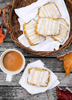 some cookies are sitting next to a cup of coffee on a table with autumn leaves