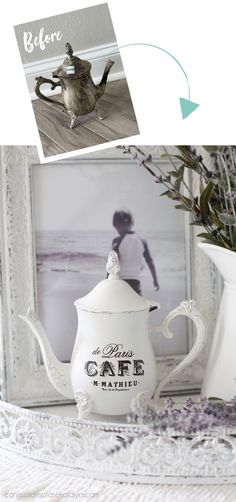 an old teapot is sitting on a table next to a vase with flowers in it