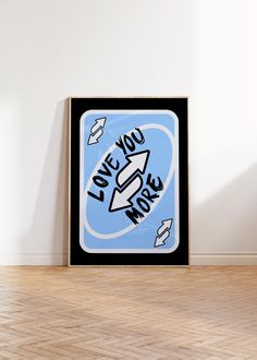 a black and blue poster with the words love you more on it in front of a white wall